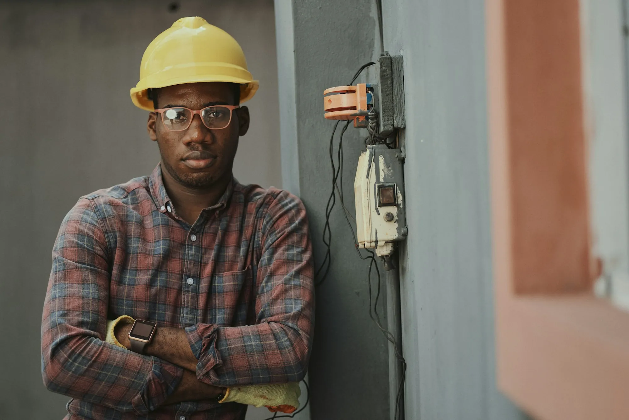 An electrician standing beside an exterior enclosure