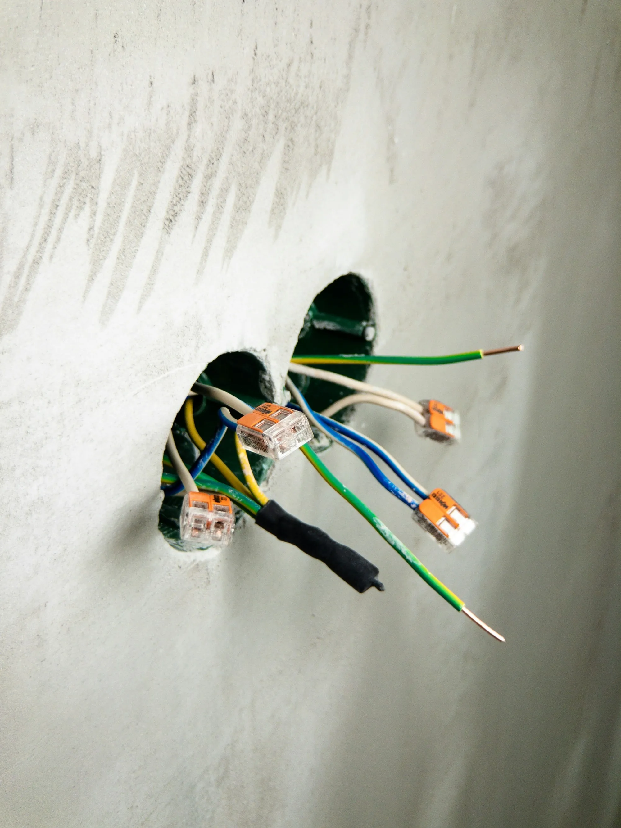 Bundles of colored wires with push connectors coming out of two wall boxes